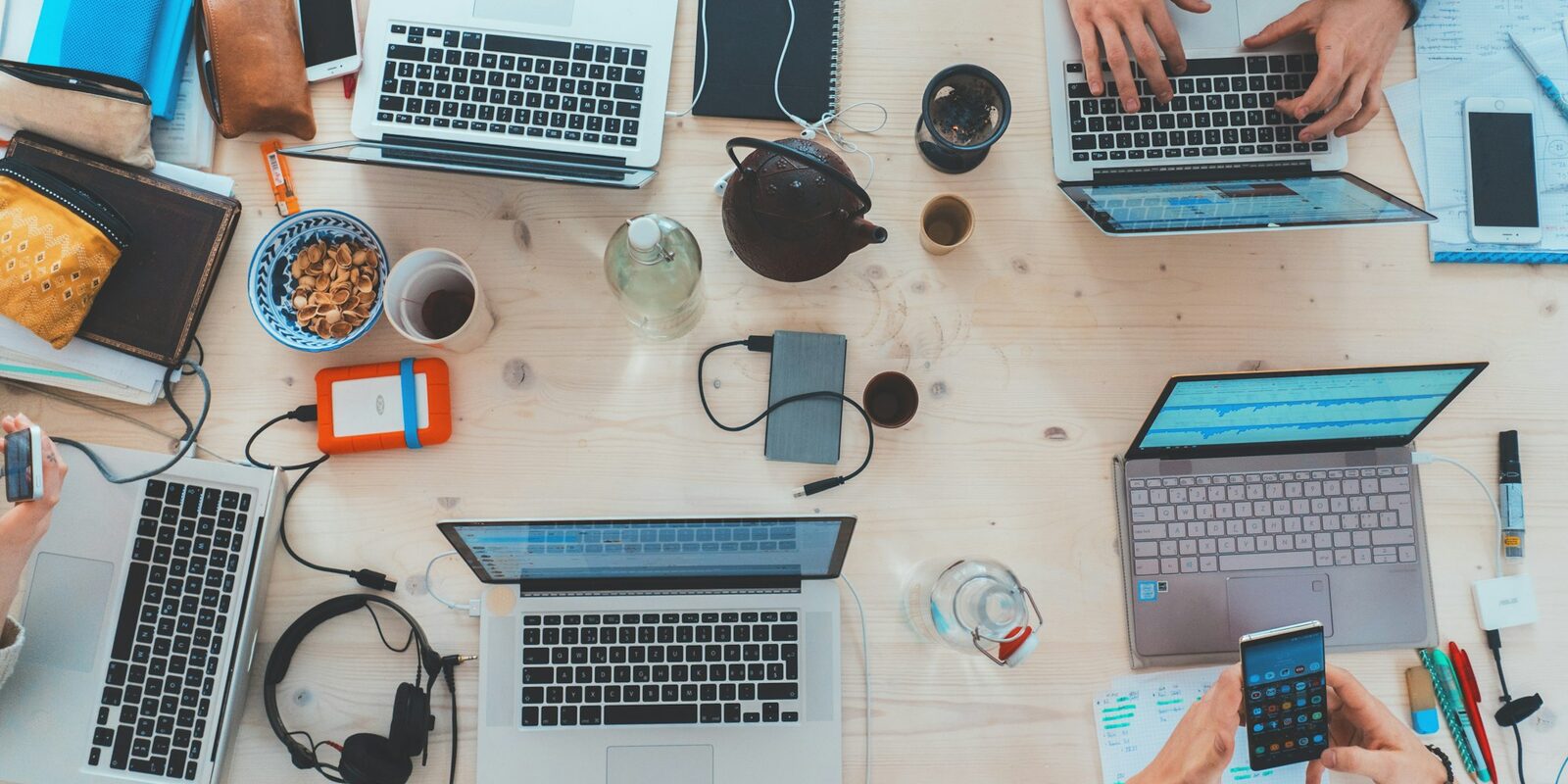 A team collaborating around laptops at a shared desk